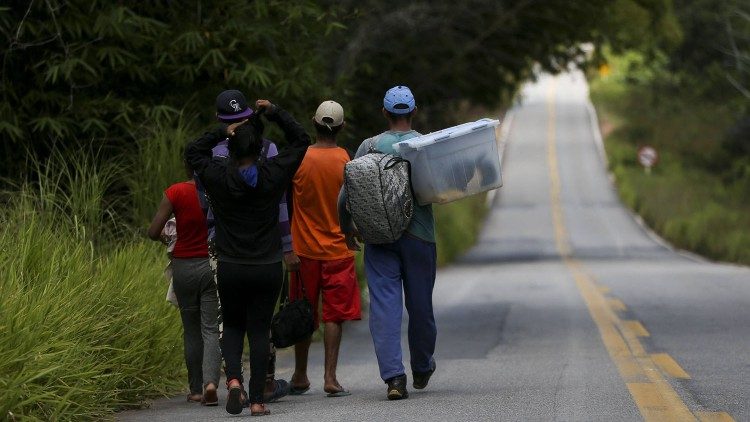 Migrantes caminando por una carretera vacía